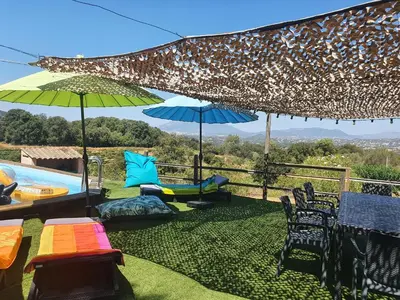 a patio with chairs and umbrellas and a pool at FORCONE in Cauro