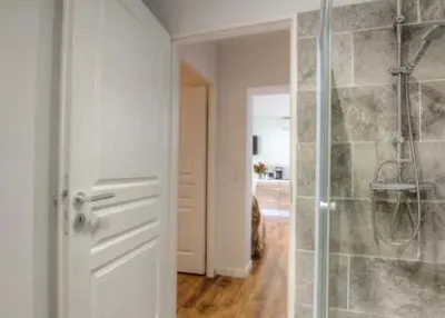 a bathroom with a shower with a glass door at Appartement tranquille en bas de villa in Afa