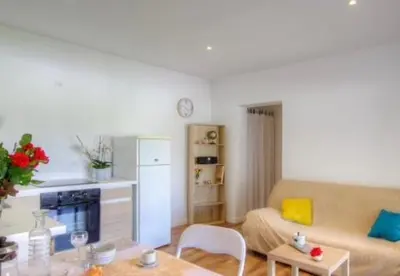 a living room with a couch and a table at Appartement tranquille en bas de villa in Afa