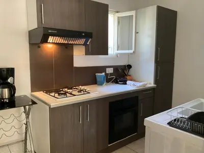 a small kitchen with a stove and a sink at MINI VILLA BORD DE MER in San-Nicolao