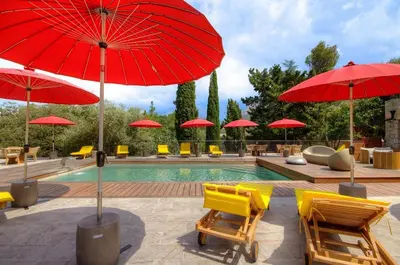 a pool with yellow chairs and red umbrellas at Hôtel Casale Olmia in Moncale