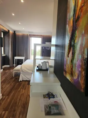 a hotel room with a bed and a painting on the wall at Hôtel Casale Olmia in Moncale