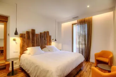 a bedroom with a large white bed and a chair at Hôtel Casale Olmia in Moncale