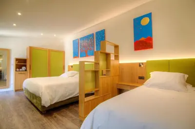 a bedroom with two beds and a book shelf at Hôtel Casale Olmia in Moncale