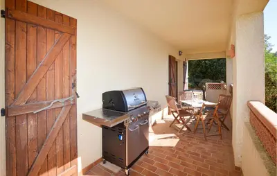 a door to a patio with a stove and a table at Cozy Apartment In Porticcio With Wifi in Porticcio