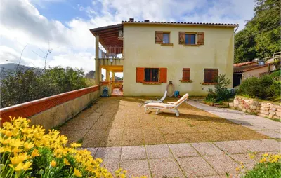 a house with a bench in front of it at Cozy Apartment In Porticcio With Wifi in Porticcio