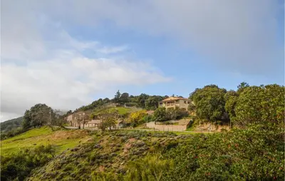 a house on top of a hill with trees at Cozy Apartment In Porticcio With Wifi in Porticcio