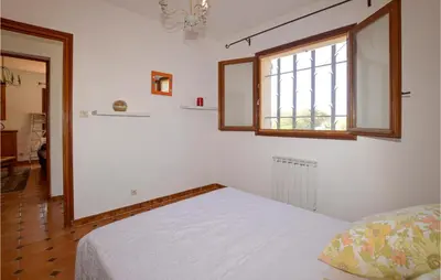 a bedroom with a bed and a window at Cozy Apartment In Porticcio With Wifi in Porticcio