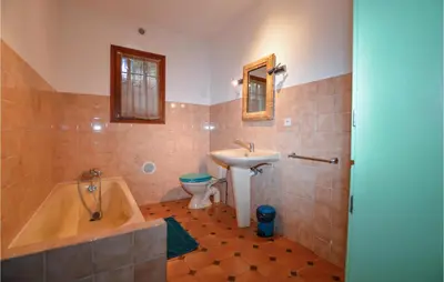 a bathroom with a tub and a sink and a toilet at Cozy Apartment In Porticcio With Wifi in Porticcio