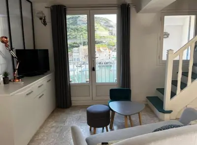 a living room with a couch and chairs and a window at Appartement duplex plein sud sur le port de Bonifacio in Bonifacio