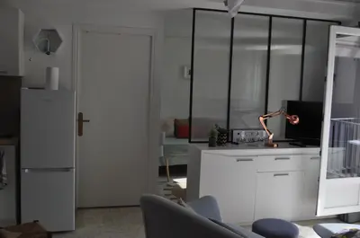 a kitchen with white cabinets and a refrigerator at Appartement duplex plein sud sur le port de Bonifacio in Bonifacio