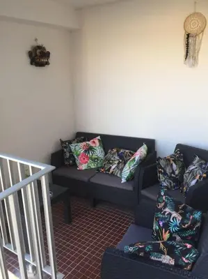 a living room with two couches with pillows at Appartement duplex plein sud sur le port de Bonifacio in Bonifacio