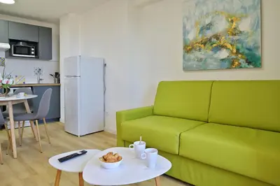 a living room with a green couch and a table at Résidence Easy Lodge in Ajaccio