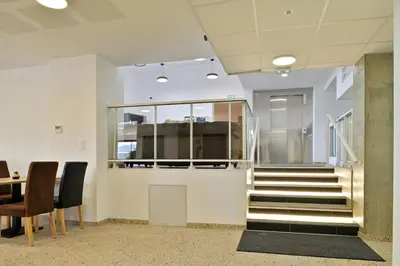 an office lobby with stairs and a table and chairs at Résidence Easy Lodge in Ajaccio