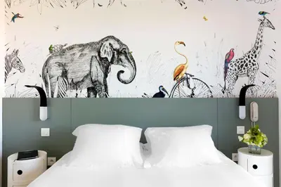 a bedroom with a bed and a mural of animals at Hotel Alcyon in Porto-Vecchio