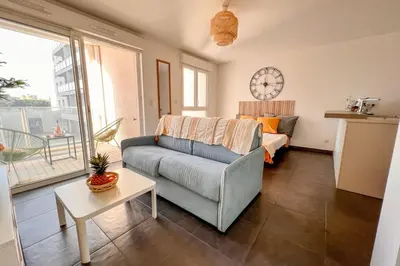 a living room with a couch and a clock on the wall at Gina - Modern Luminous Balcony - by TGB in Ajaccio