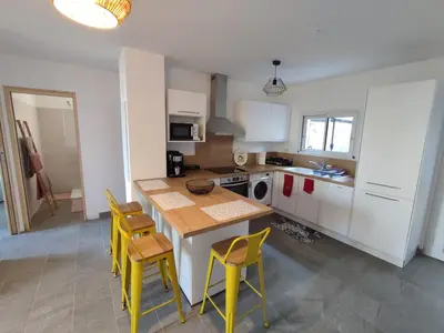 a kitchen with a table and some yellow chairs at Olmeto 3 pièces in Olmeto