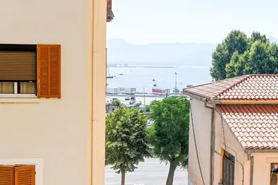 a bedroom with a large white bed with an orange wall at Alba - Central Glimpse of the sea Sea nearby in Ajaccio
