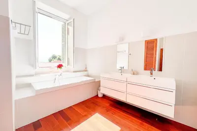 a bedroom with a large white bed with two pillows at Alba - Central Glimpse of the sea Sea nearby in Ajaccio