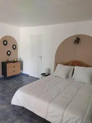 a bedroom with a large white bed and a dresser at Les bergeries de Montestremo in Manso