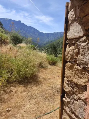 a stone wall with a view of the mountains at Les bergeries de Montestremo in Manso