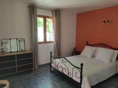 a bedroom with a bed and a mirror and a window at Les bergeries de Montestremo in Manso