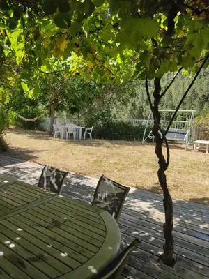 a picnic table and chairs under a tree in a yard at Les bergeries de Montestremo in Manso