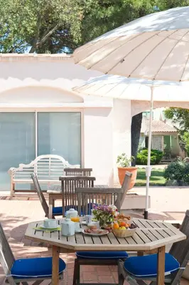 a table with an umbrella and fruit on a patio at Résidence Domaine De Caranella in Porto-Vecchio