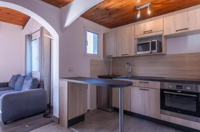 a kitchen with a table and a couch in a room at Résidence Domaine De Caranella in Porto-Vecchio