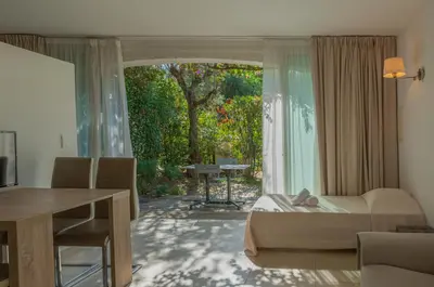 a living room with a couch and a table and a window at Résidence Domaine De Caranella in Porto-Vecchio