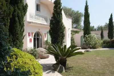 a house with a palm tree in the yard at Résidence Domaine De Caranella in Porto-Vecchio