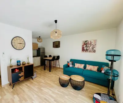 a living room with a blue couch and a table at Ajaccio T2 grand standing neuf - centre ville et plages - 4 personnes - parking privé in Ajaccio