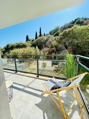a chair on a balcony with a view of trees at Ajaccio T2 grand standing neuf - centre ville et plages - 4 personnes - parking privé in Ajaccio