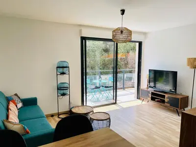 a living room with a blue couch and a tv at Ajaccio T2 grand standing neuf - centre ville et plages - 4 personnes - parking privé in Ajaccio