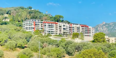 a large apartment building on a hill with trees at Ajaccio T2 grand standing neuf - centre ville et plages - 4 personnes - parking privé in Ajaccio