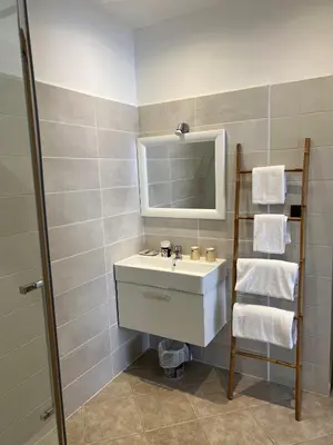 a bathroom with a sink and a mirror and towels at Les Jardins De Santa Giulia - Charmante chambre dhte in Porto-Vecchio