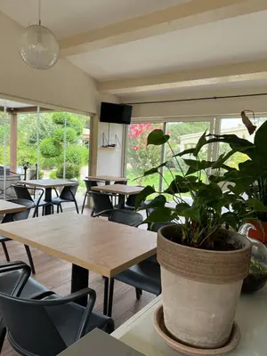 a restaurant with tables and chairs and a potted plant at Les Jardins De Santa Giulia - Charmante chambre dhte in Porto-Vecchio