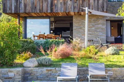 two chairs sitting in the grass in front of a house at Villa Santa Lucia Di Fautea in Sainte-Lucie de Porto-Vecchio