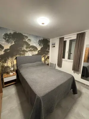 a bedroom with a bed and a painting on the wall at Chez Jeff Lucchini in Lecci