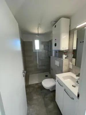 a white bathroom with a toilet and a sink at Chez Jeff Lucchini in Lecci