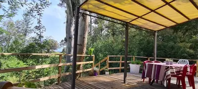 a patio with a table and chairs on a deck at Résidence Santa in Ghisonaccia