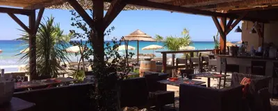 a restaurant on the beach with tables and umbrellas at Le Pélican T2 Magnifique in Ajaccio