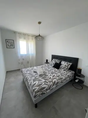 a bedroom with a large bed in a white room at Le Pélican T2 Magnifique in Ajaccio