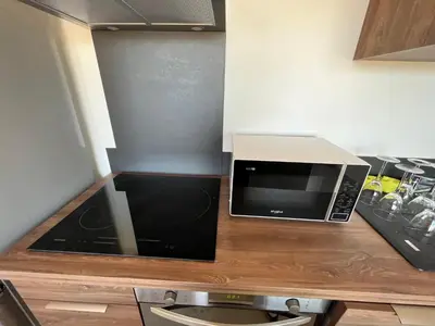 a microwave sitting on top of a wooden counter at T1 proche aéroport et plage in Ajaccio