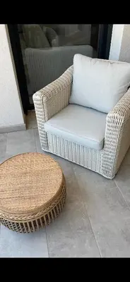 a wicker chair and a stool on a patio at T1 proche aéroport et plage in Ajaccio