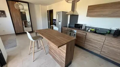 a kitchen with a wooden counter top and a stool at T1 proche aéroport et plage in Ajaccio