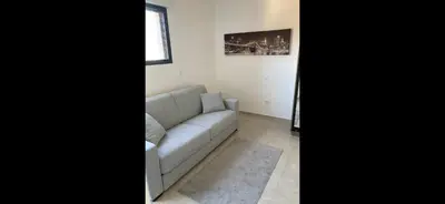 a living room with a couch and a window at T1 proche aéroport et plage in Ajaccio