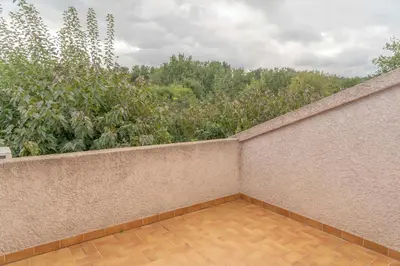 a balcony with a brick wall and trees at Residence Scopa Marina in Poggio-Mezzana