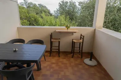 a small balcony with a table and chairs and a window at Residence Scopa Marina in Poggio-Mezzana