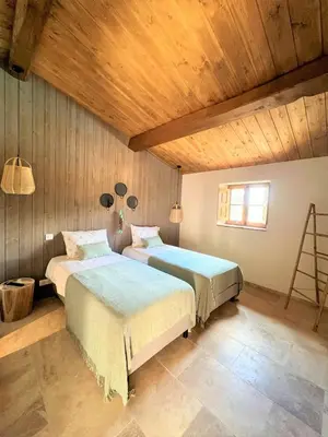two beds in a room with wooden walls and wooden ceilings at Casetta Tinuta in Sainte-Lucie de Porto-Vecchio